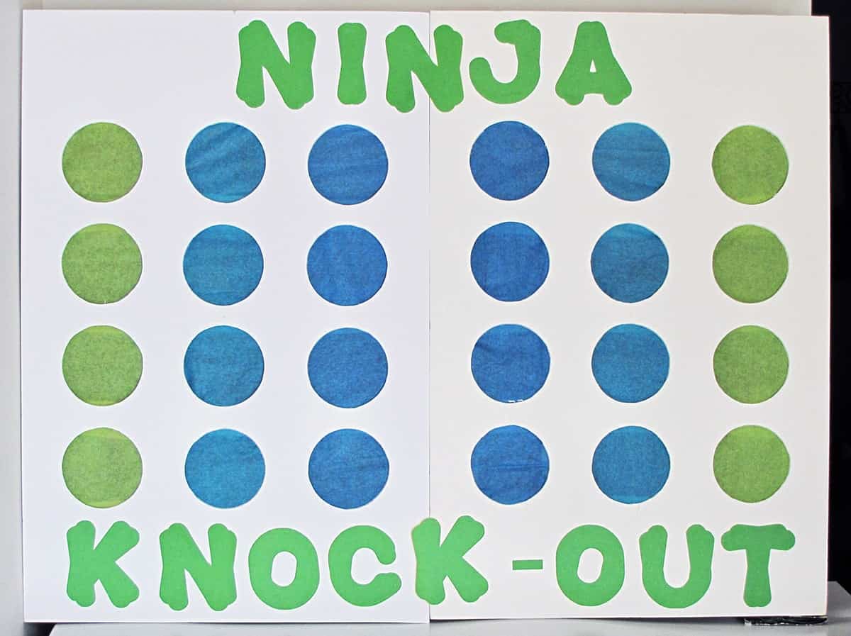 Ninja Turtle Ninja Knockout game- white board with green and blue tissue paper covered circles and green lettering. 