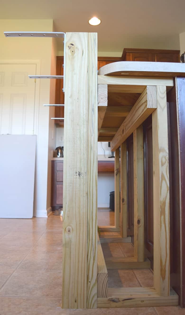 Side view of wood frame for breakfast bar addon on kitchen island with white door in background. 