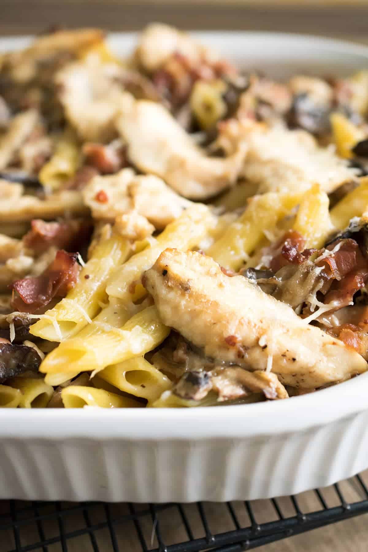 Enlarged view of creamy chicken marsala pasta with penne noodles, grilled sliced chicken, mushrooms, prosciutto, and grated parmesan.