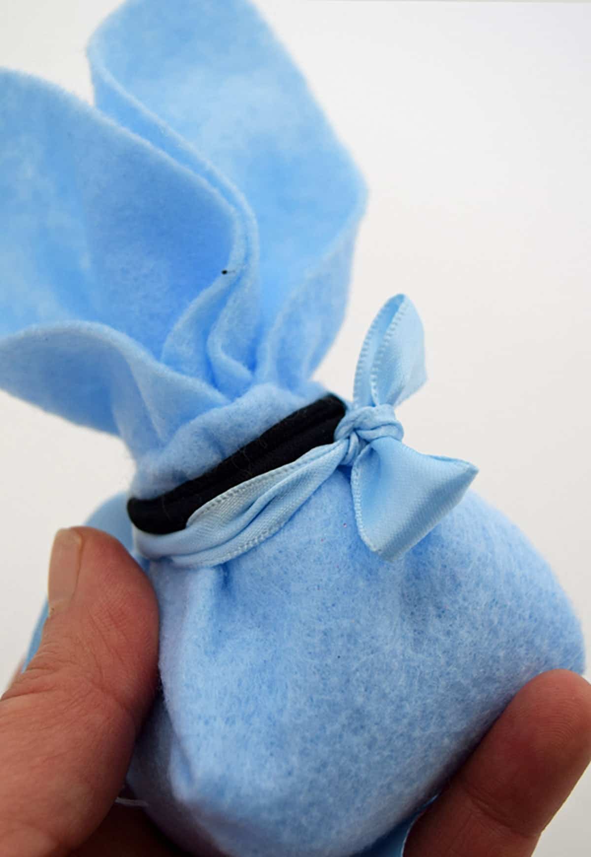 Blue felt DIY bunny pouch with closeup of hair band to secure ears. 