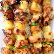 Teriyaki Chicken Kabobs overhead with pineapple and green peppers on a bed of rice.