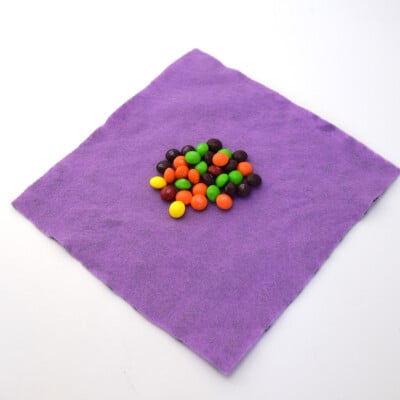 Napkin laying flat with candy in the center.