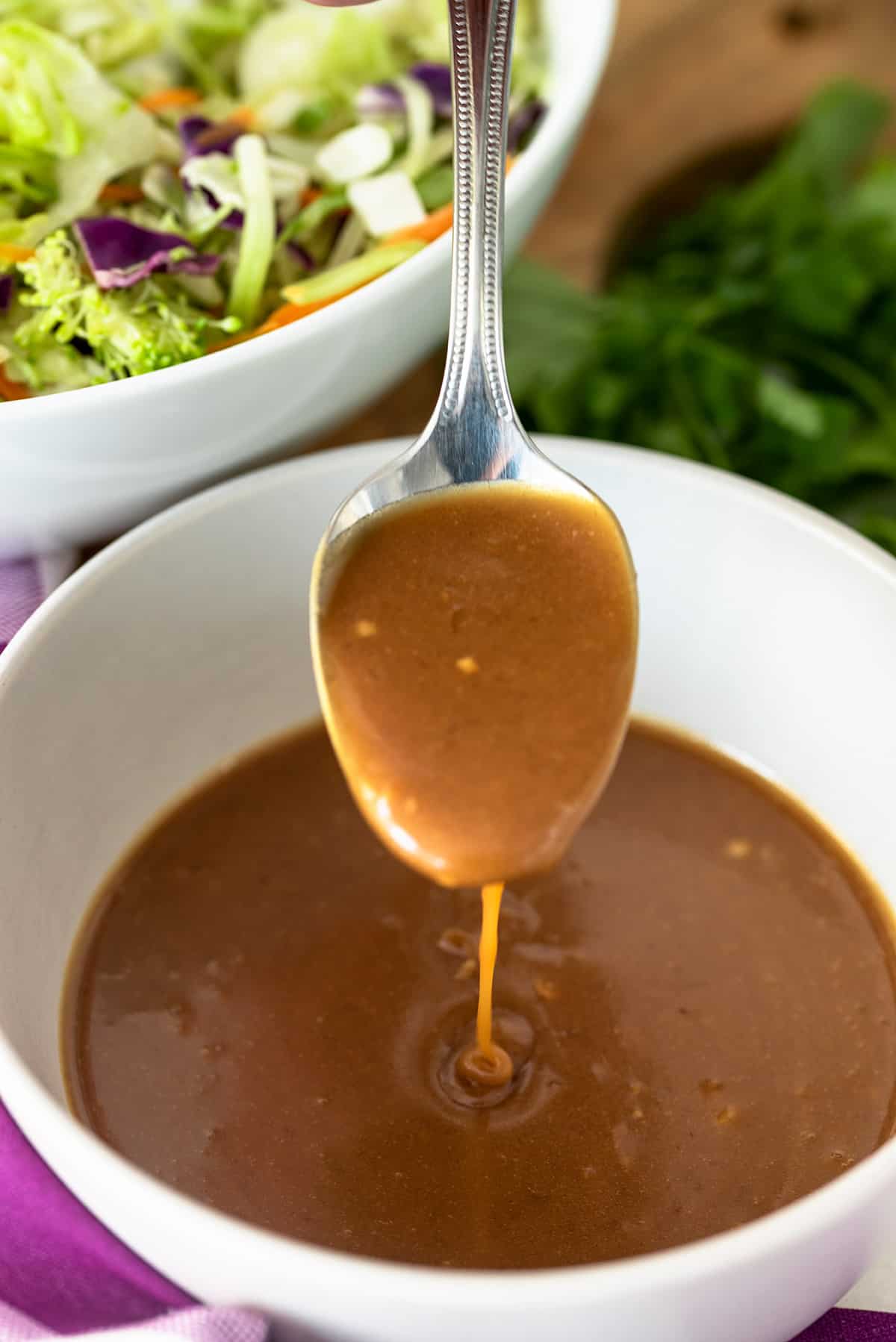 Ginger Peanut Sauce dripping off a spoon into a bowl.