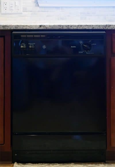 Black Dishwasher in kitchen with marble countertops.