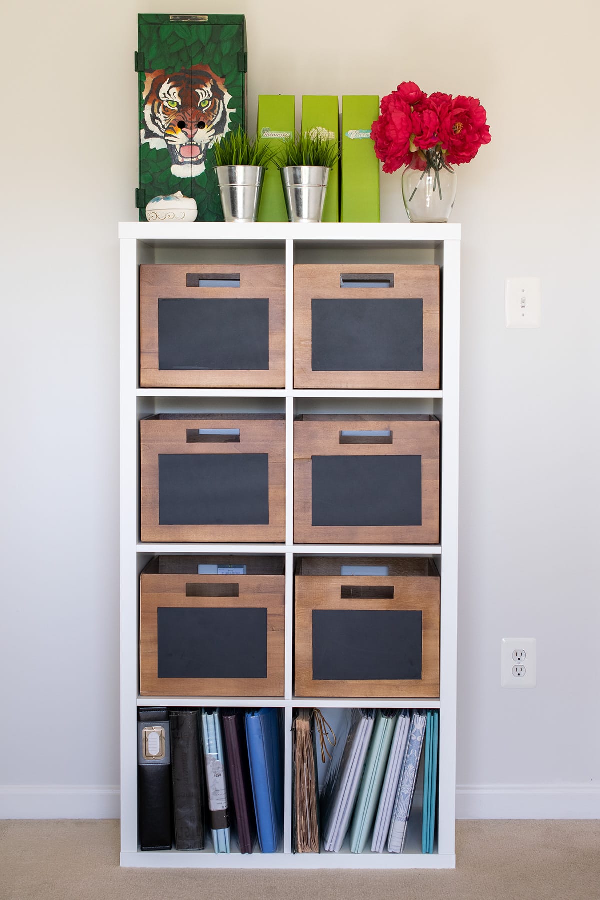 Ikea Kallax organization idea with wood storage bins with chalkboard fronts, topped with potted plants and binders. 