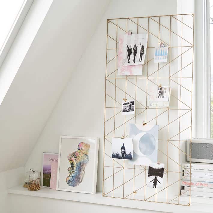 Oversized metal art frame with clips on a desk.