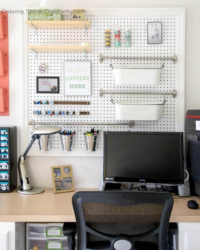 Desk area with large pegboard for craft and office supplies.