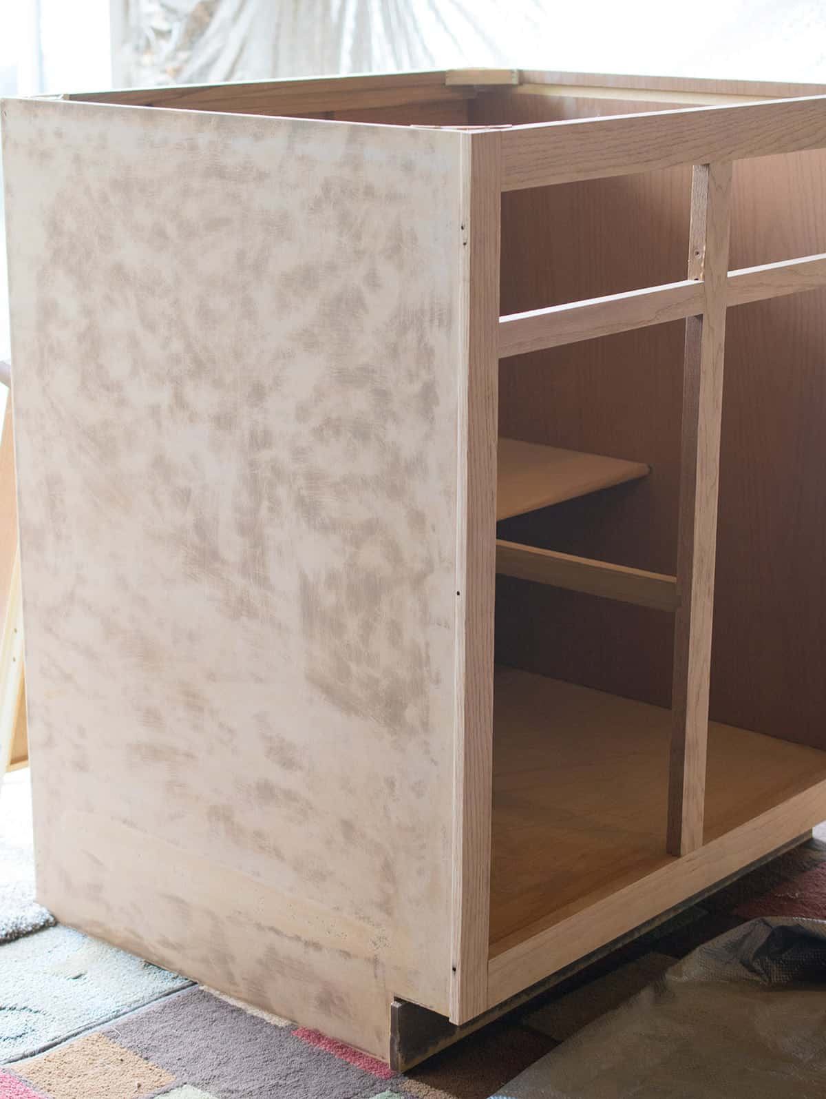 Sanded section of kitchen cabinet with doors and counter removed. 