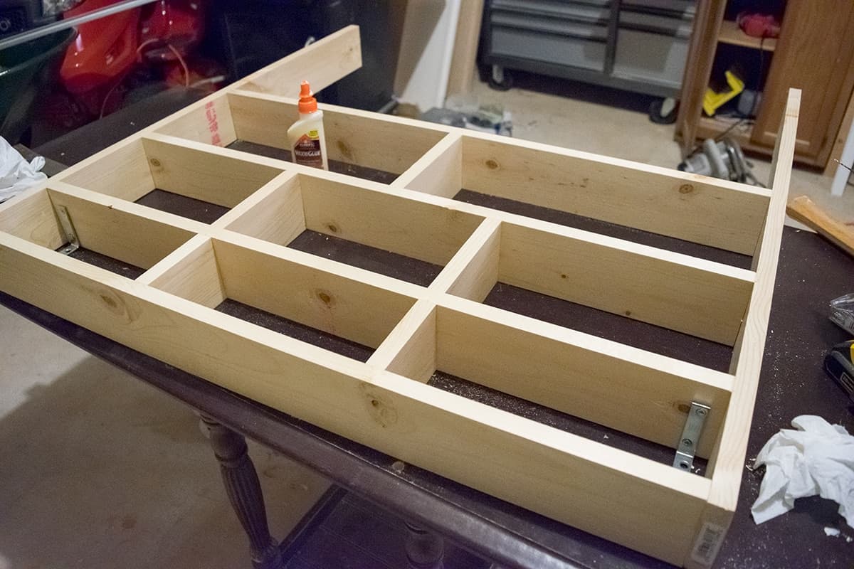 Progress of building craft room wall shelf with frame laying on table. 