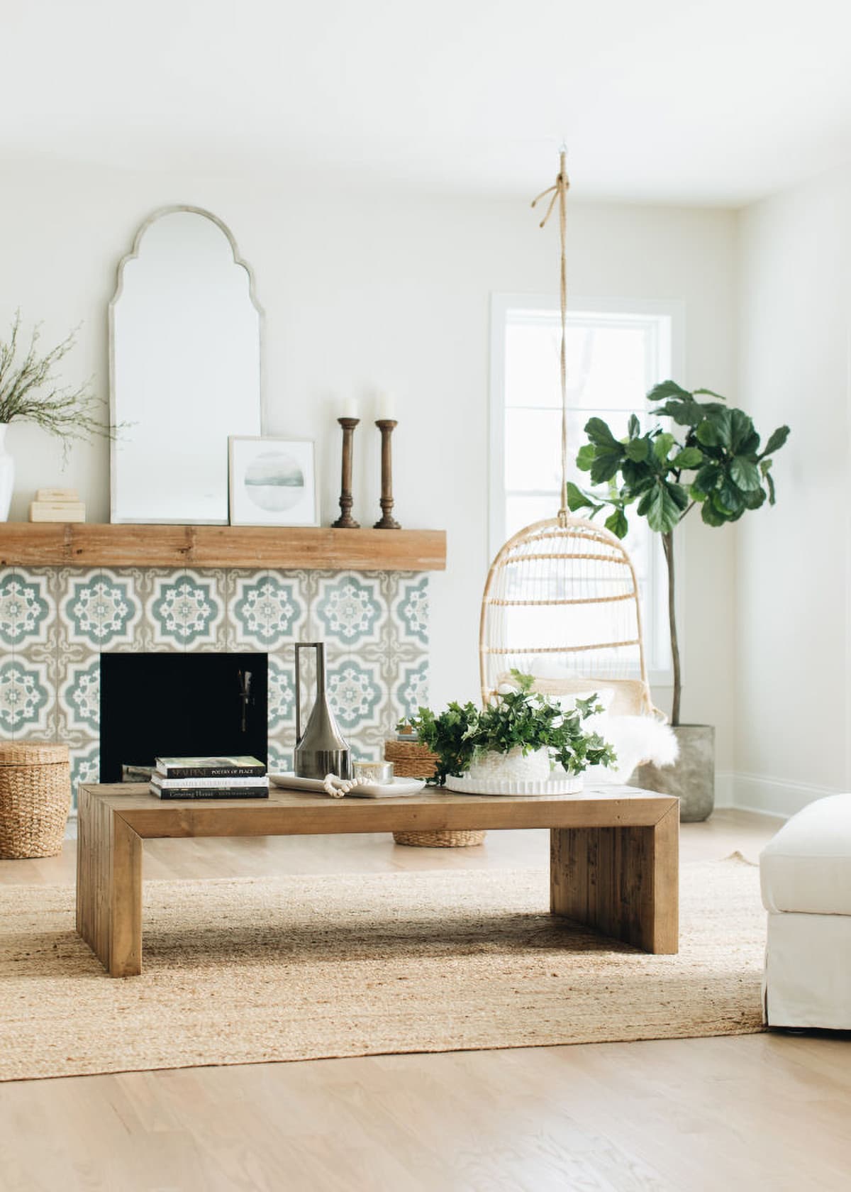 Natural beige living room with mediterranean tiled fireplace and large wooden coffee table.