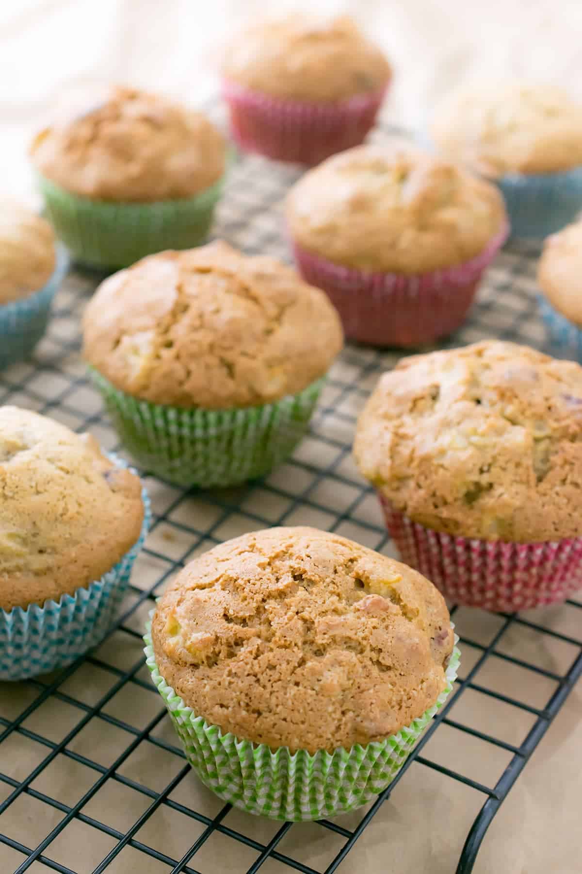 Squash muffins on a baking rack with colorful muffin liners.