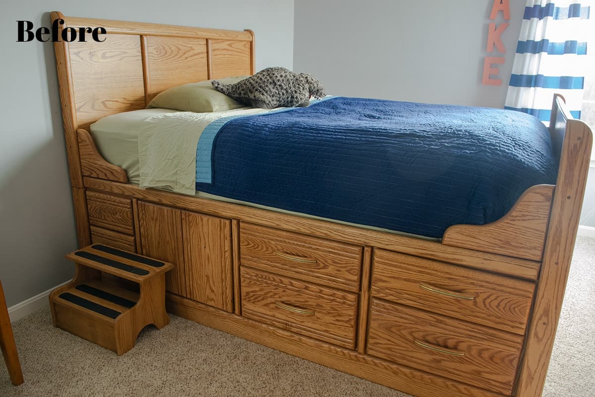 Wood captain's bed with step stool with navy blue comforter in little boy's room.