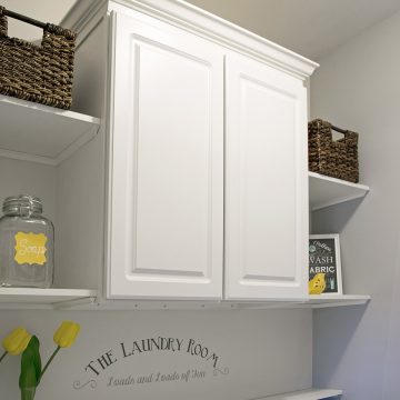 Laundry room cabinets and shelves above a washer and dryer in small laundry room.