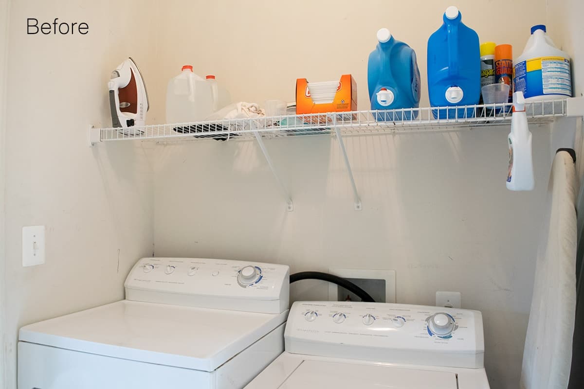 Basic white laundry room with white appliances with simple rack shelf with laundry supplies. 