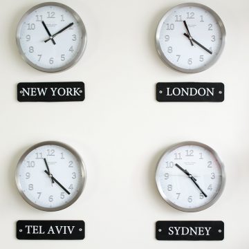 Four clocks with different locations listed below them as a world time zone display.