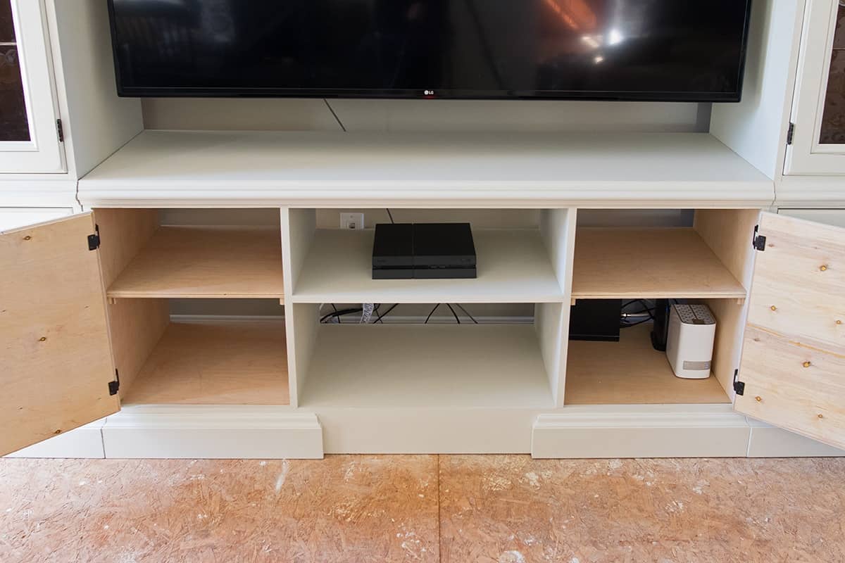 Open doors in new TV console center of a DIY entertainment center paint project. 