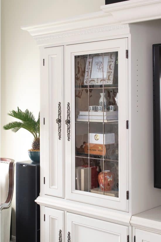 Cream painted entertainment center with glass doors.