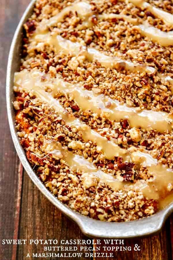 Buttered pecan topped sweet potato casserole with carnalized marshmallow drizzle in meatal baking dish. 