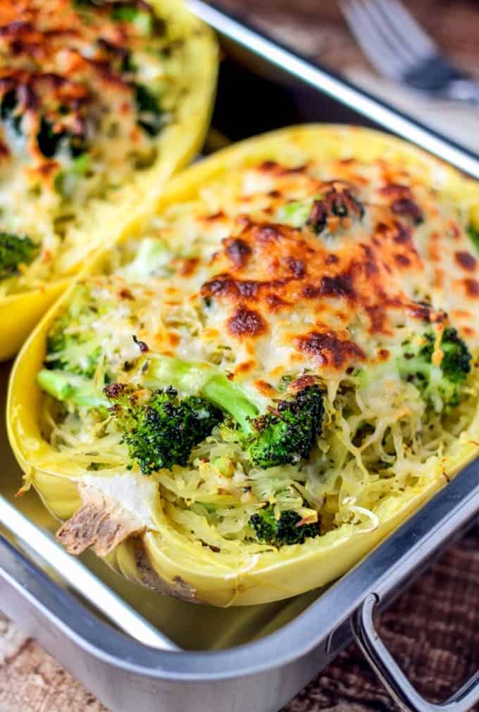 Broccoli and cheese stuffed spaghetti squash on metal baking dish. 