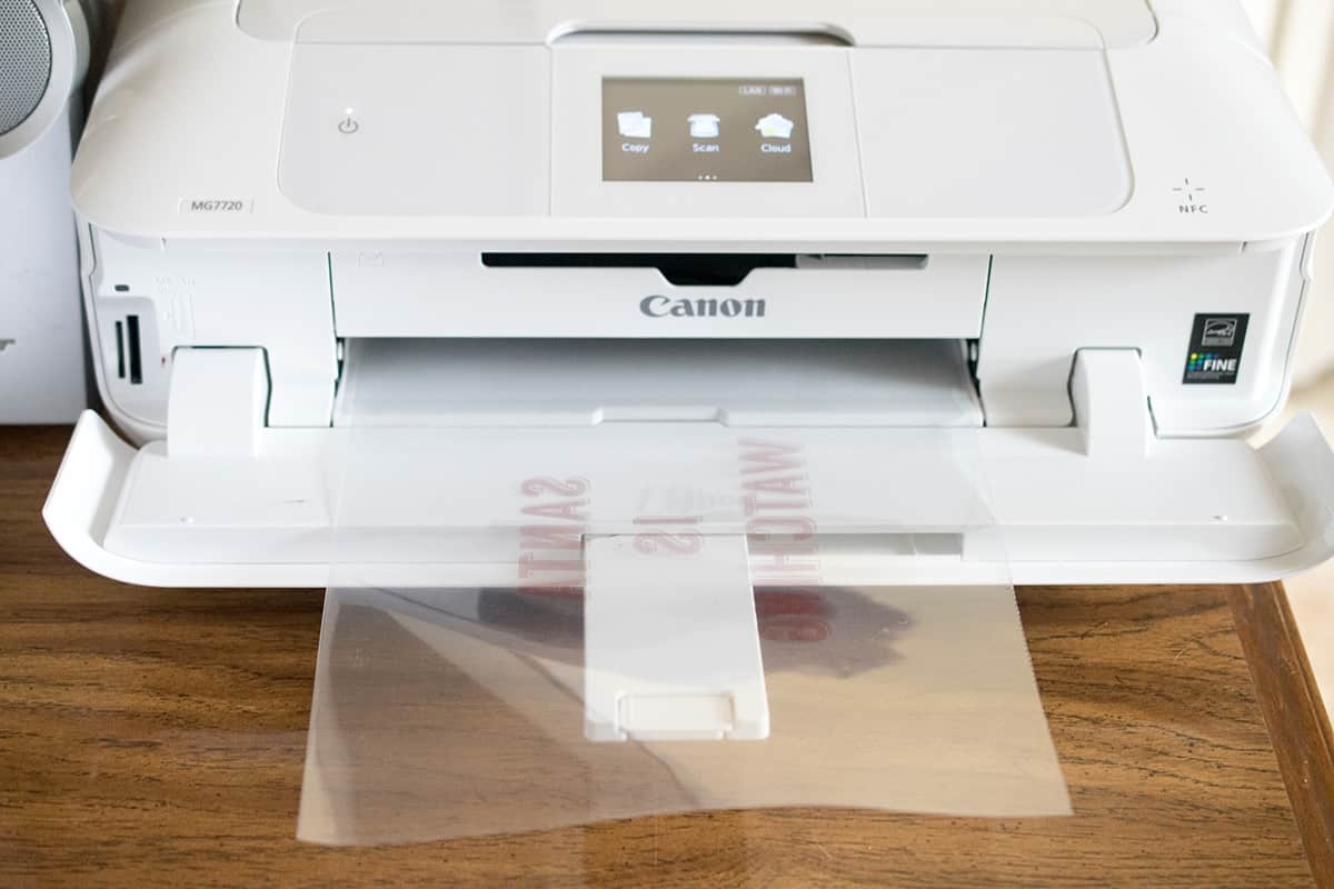 Canon inkjet printer with plastic sheet coming out of the front after printing onto.