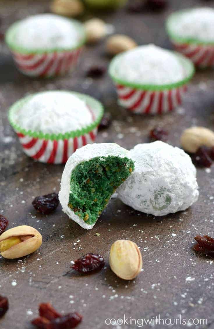 Grinch cookies or green snowball cookies laid out with one bite taken out so that you see the green centers.