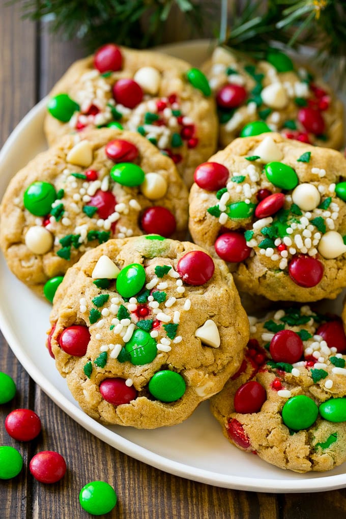 Monster cookies with christmas sprinkles and m&ms on a plate.