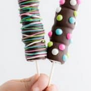 Two marshmallow pops dipped in chocolate and sprinkled with candies on top. how to make chocolate dipped marshmallow pops - easy decorating idea and fun to make with the kids. Add candies and colors!