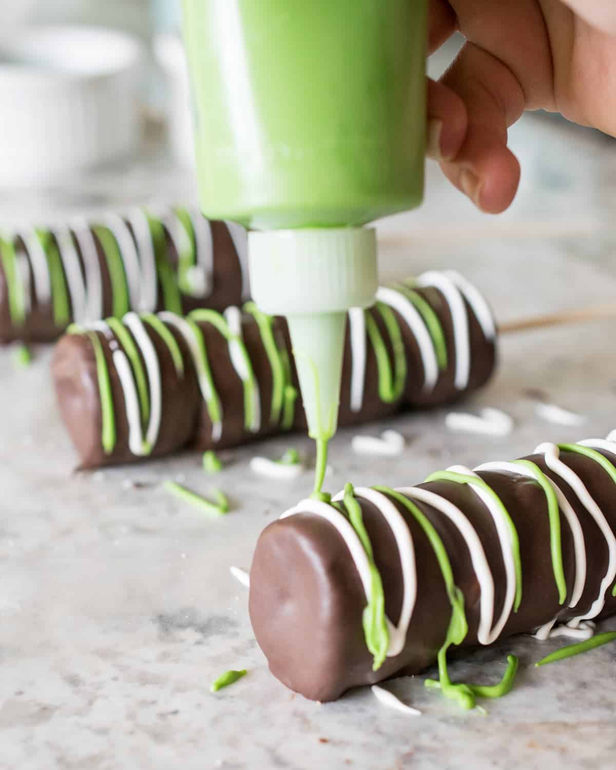 Squeezable chocolate sauce bottle show how to decorating chocolate dipped balls by writing.