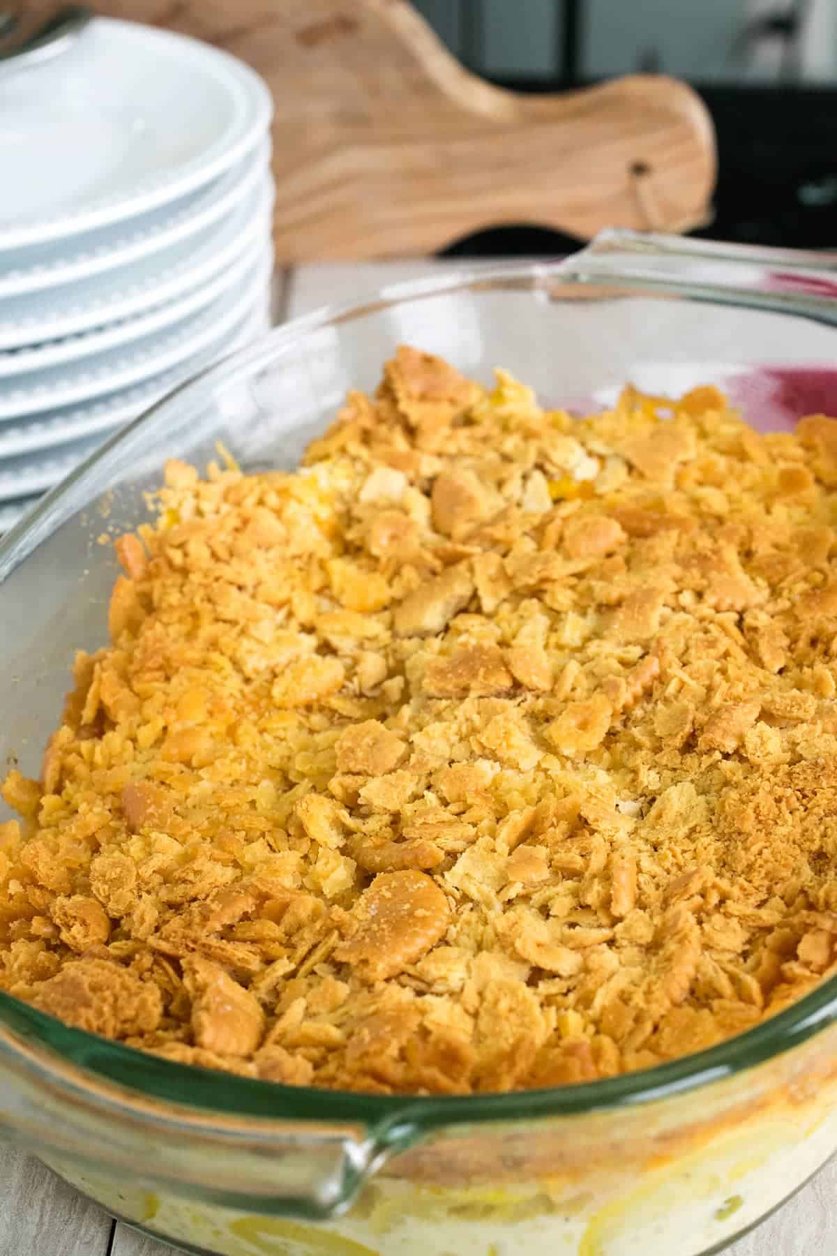 Tender and delicious southern squash casserole topped with buttery ritz cracker crust in glass baking dish. 
