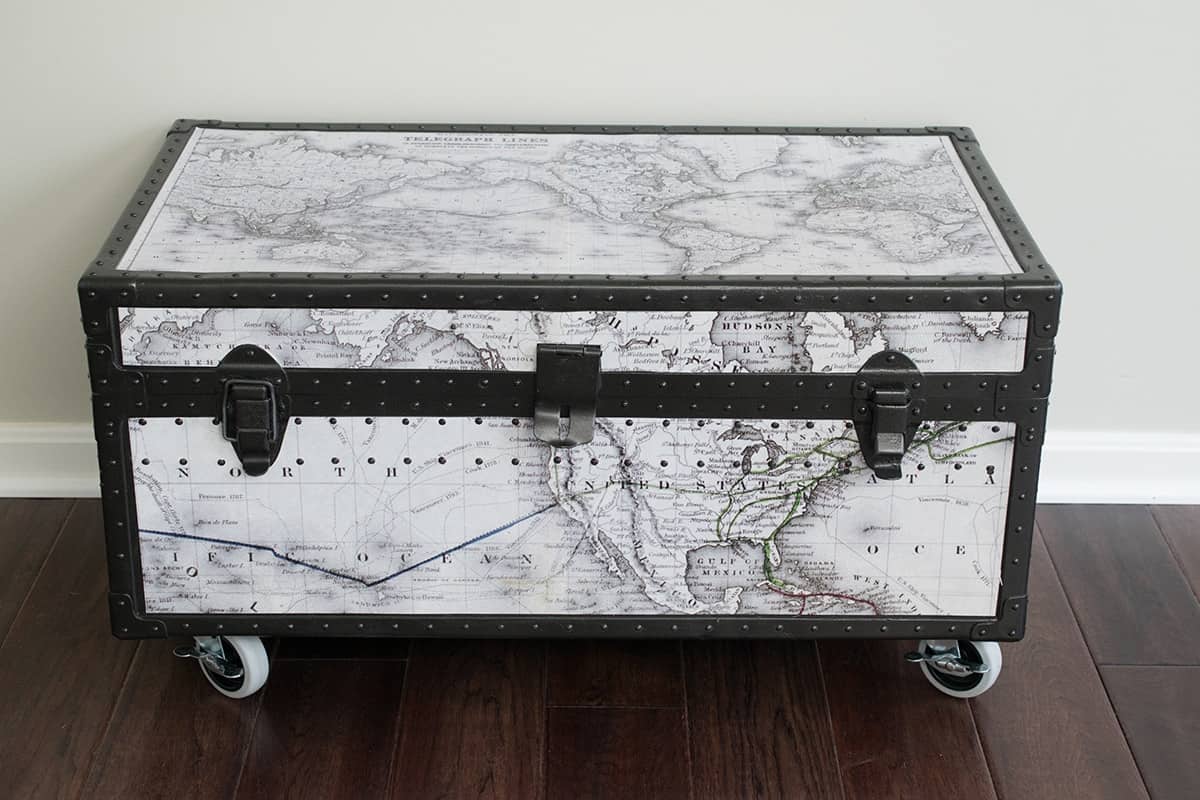 Vintage metal military foot locker makeover with black and white vintage map covering the top and sides.