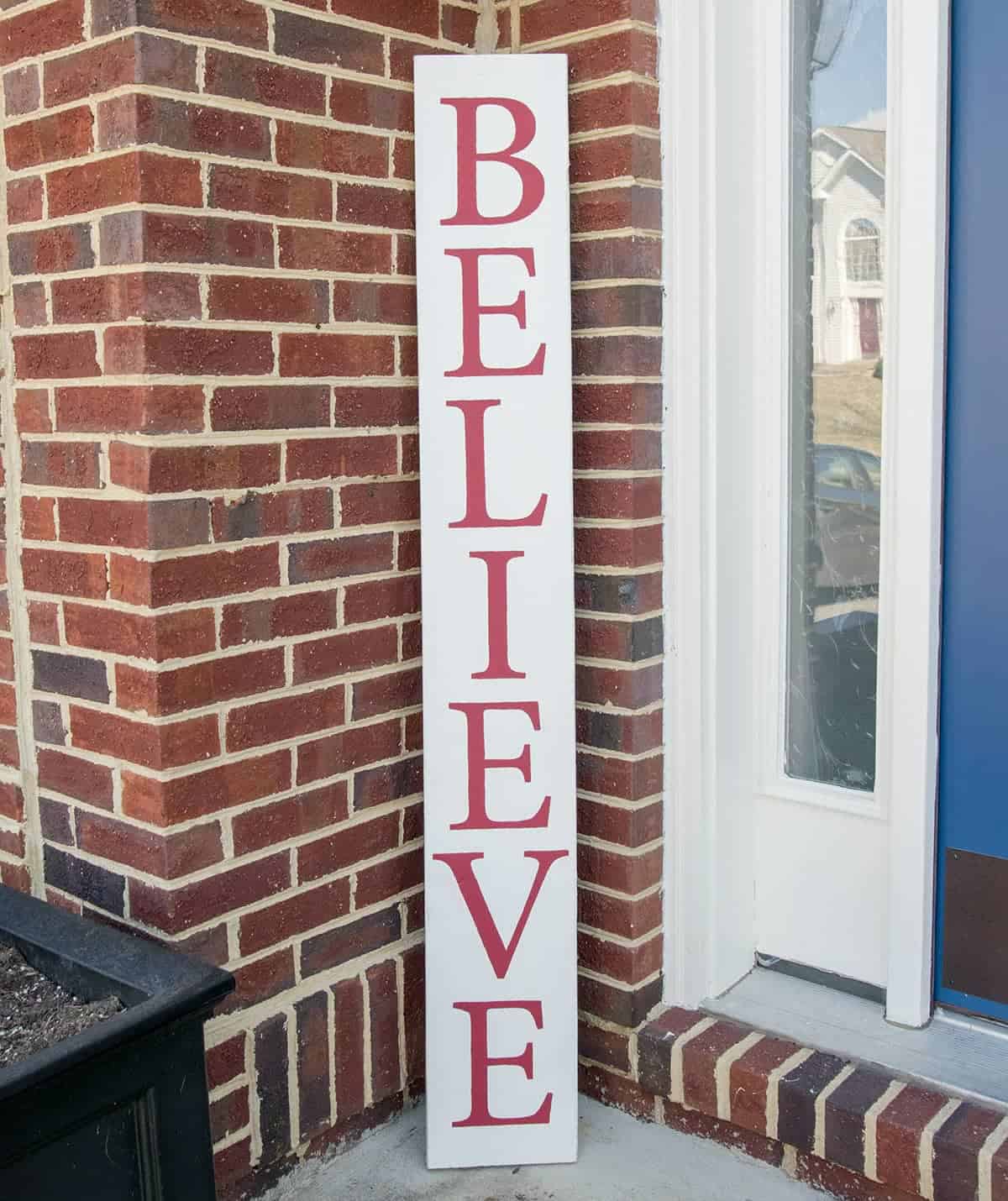 DIY believe Christmas welcome sign in red and white by front door.