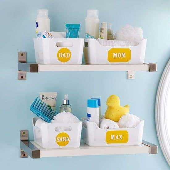 White and metal free-floating shelves in bathroom with individual personalized baskets for the whole family. 