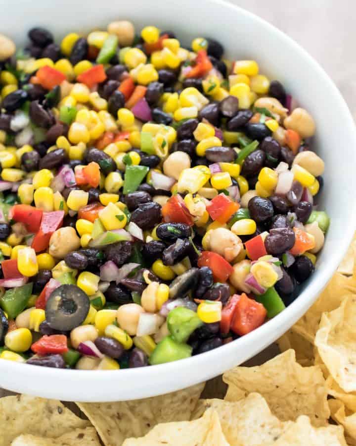 Corn and black bean salad in a bowl with vinaigrette dressing.