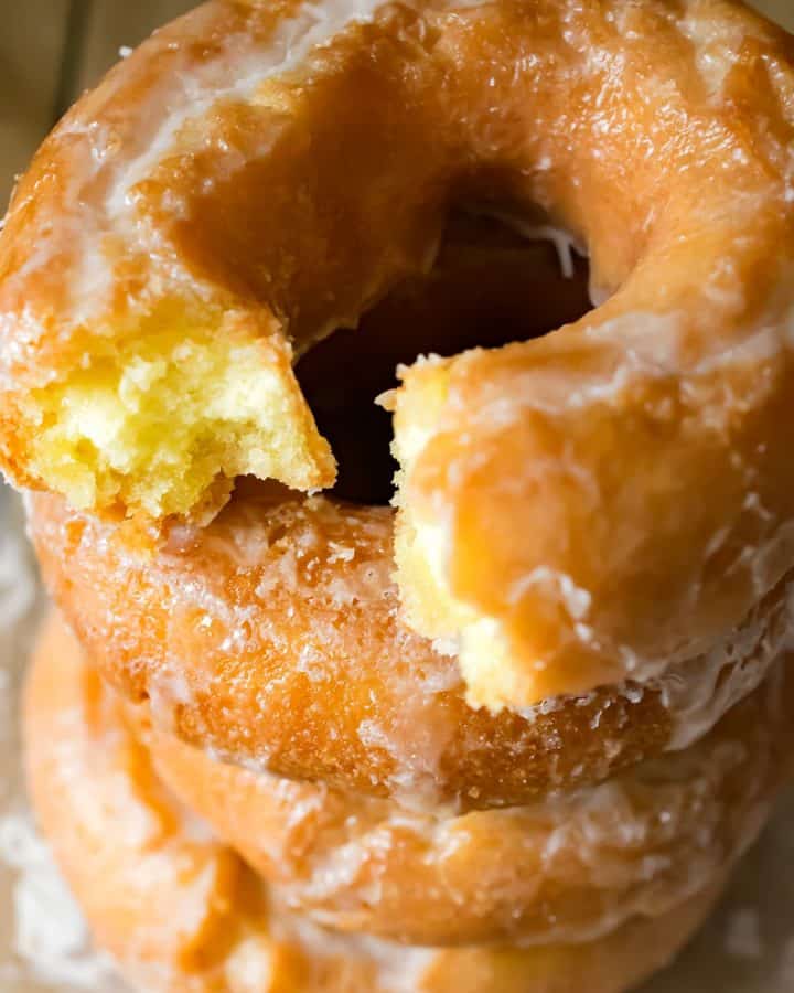 Closeup of stack of old fashioned doughnuts with the top broken in half.