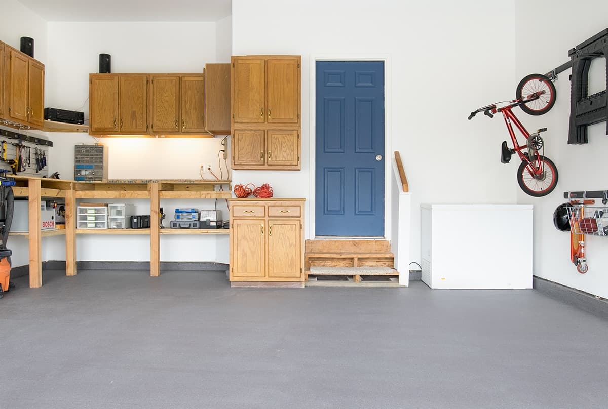 Garage with gray painted floor that is clean and organized.