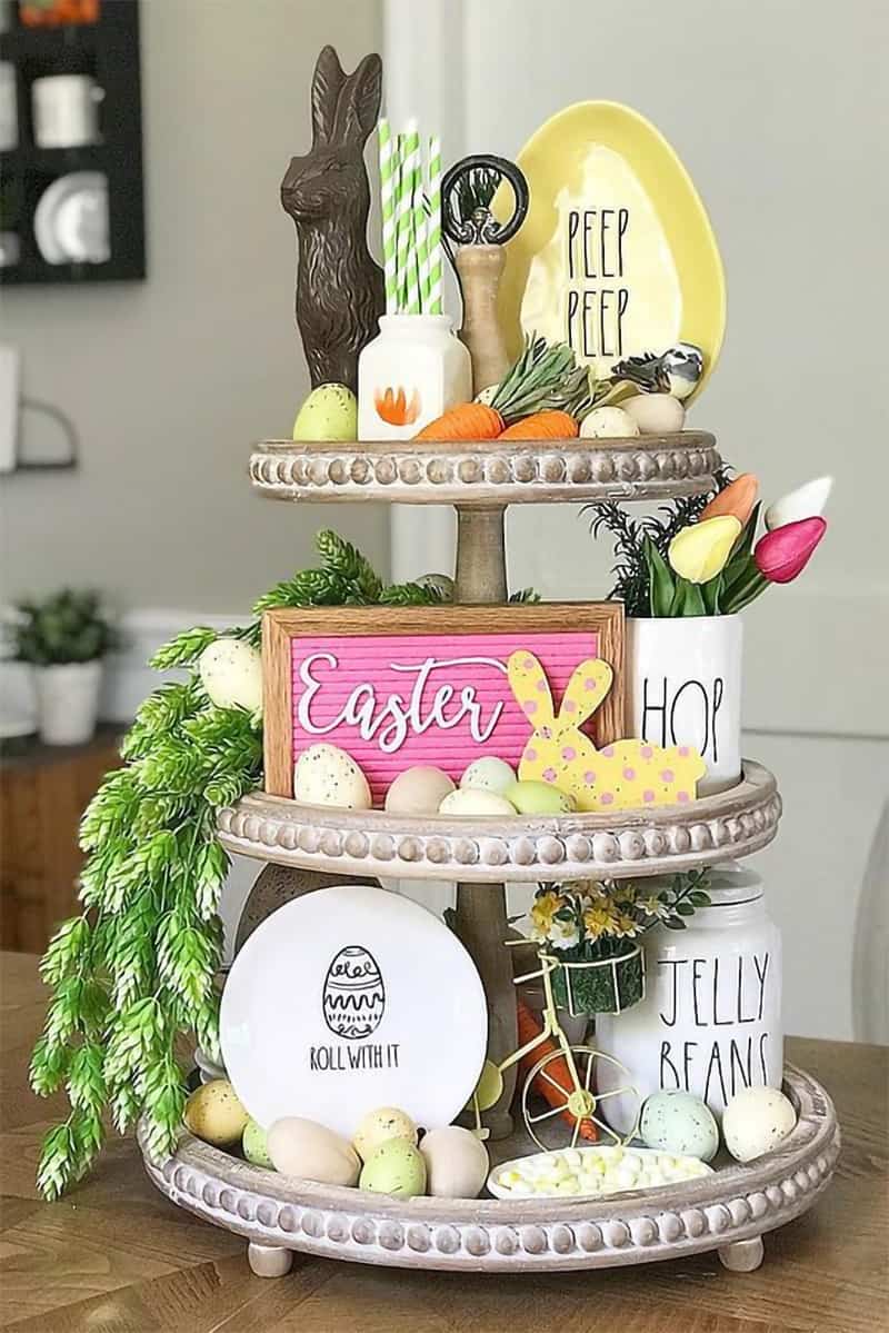 Easter themed tiered tray decorations with small signs and chocolate bunny.