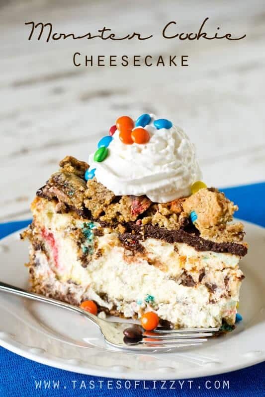 Monster cookie cheesecake on white plate with chunks of M&M's cookies, chocolate ganache, and whipped cream topping. 