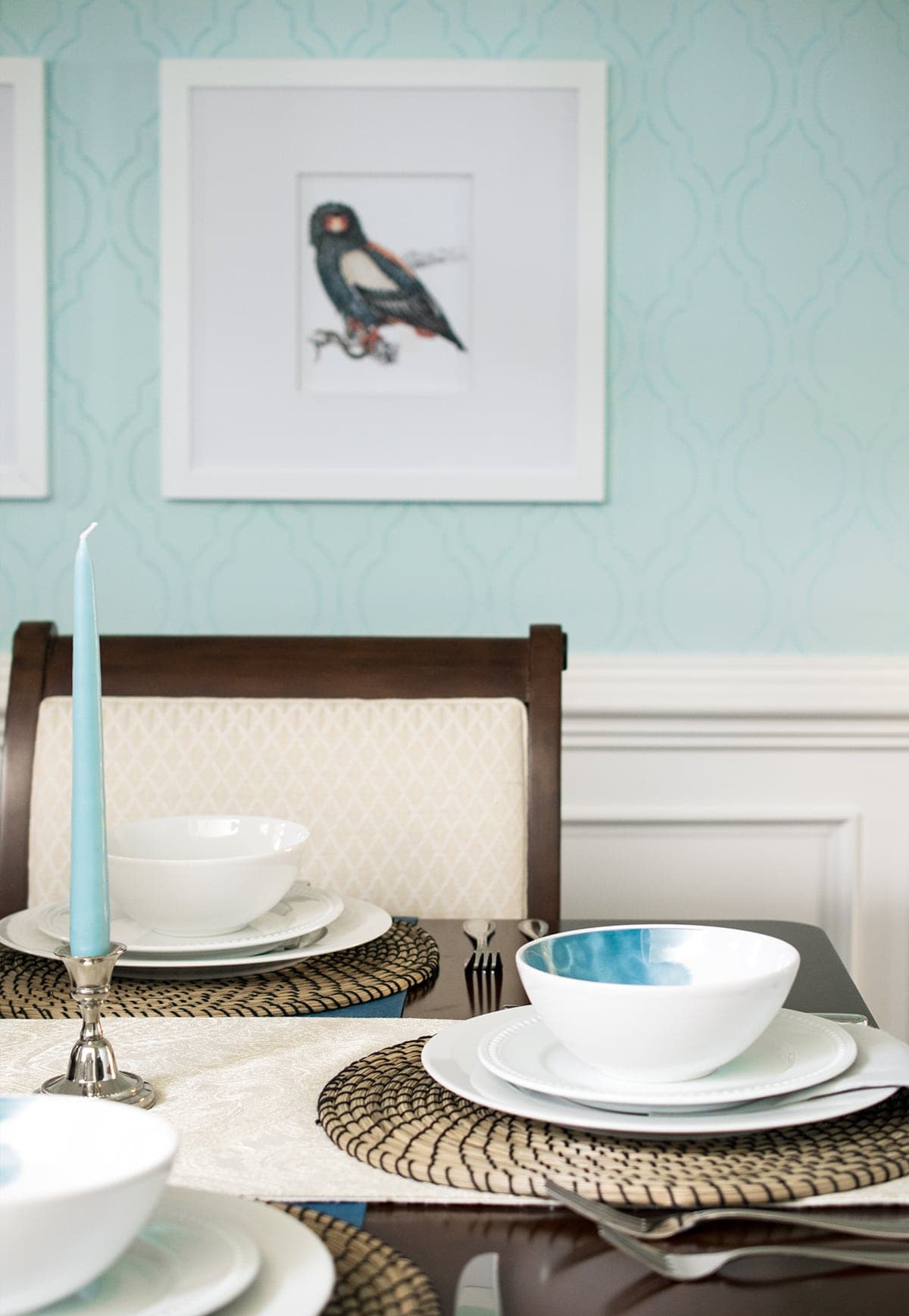 Stenciled blue dining room wall detail with white hanging birdlife art