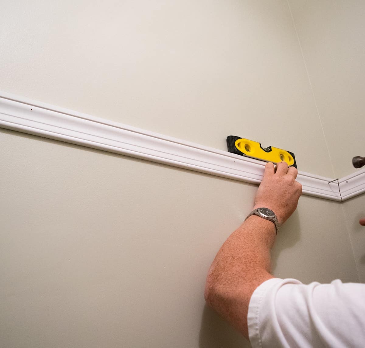 Process of hanging wall cabinets using a ledger board and a level.