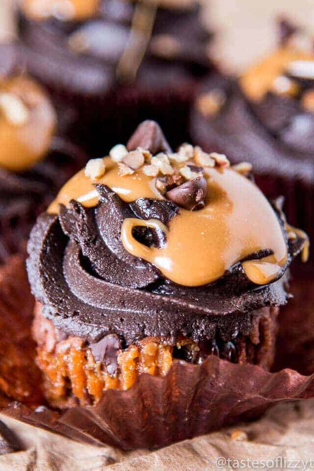 Chocolate caramel turtle cupcakes topped with luscious chocolate, caramel drizzle, and chopped pecans 