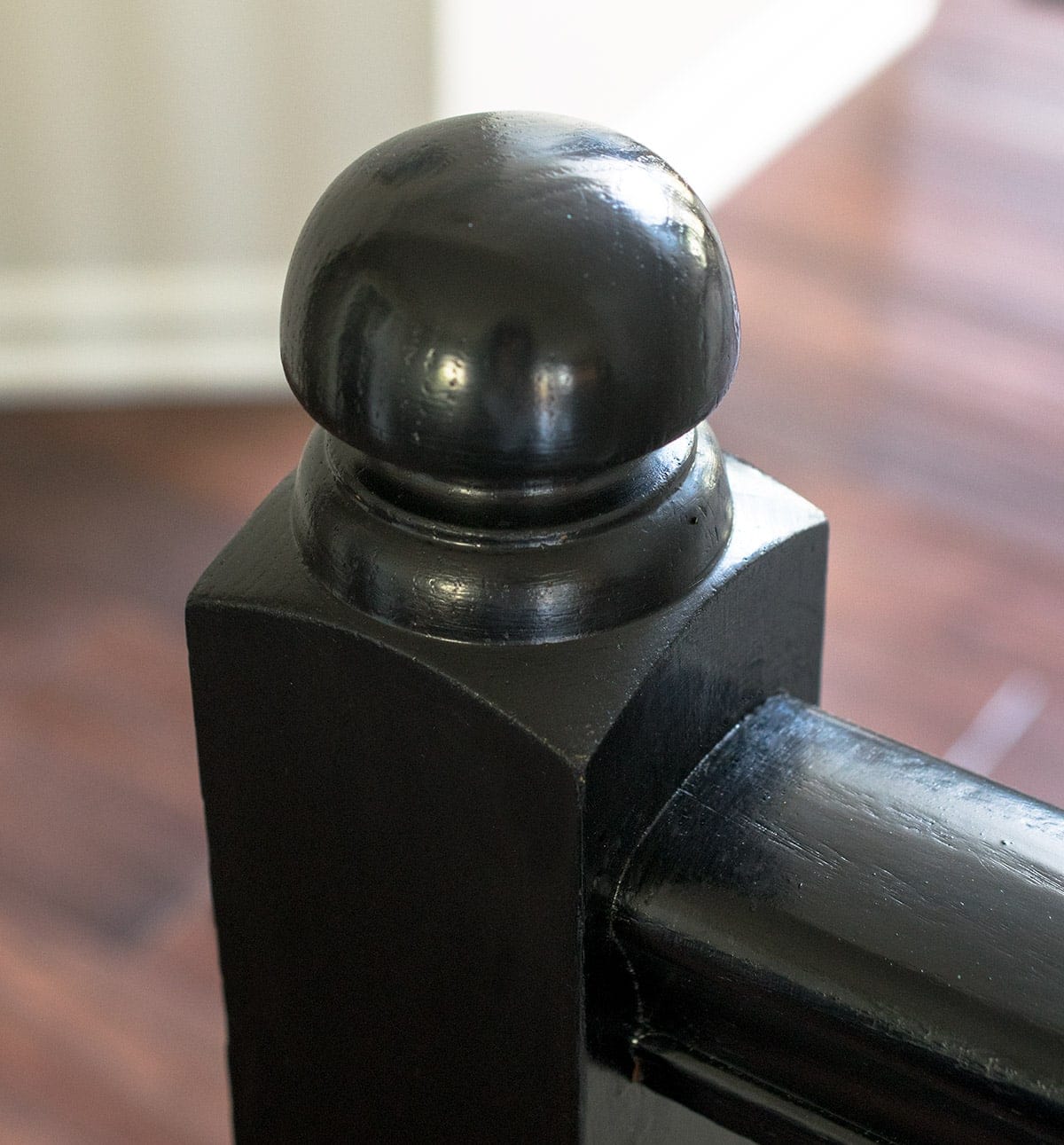 Closeup of paint without brush strokes on newel post and cap in stairwell 