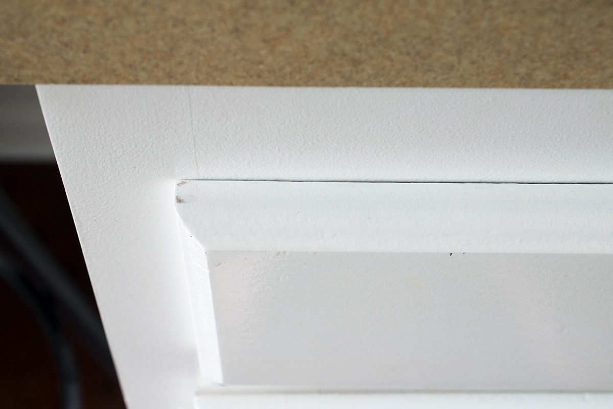 Corner detail on white cabinet panel