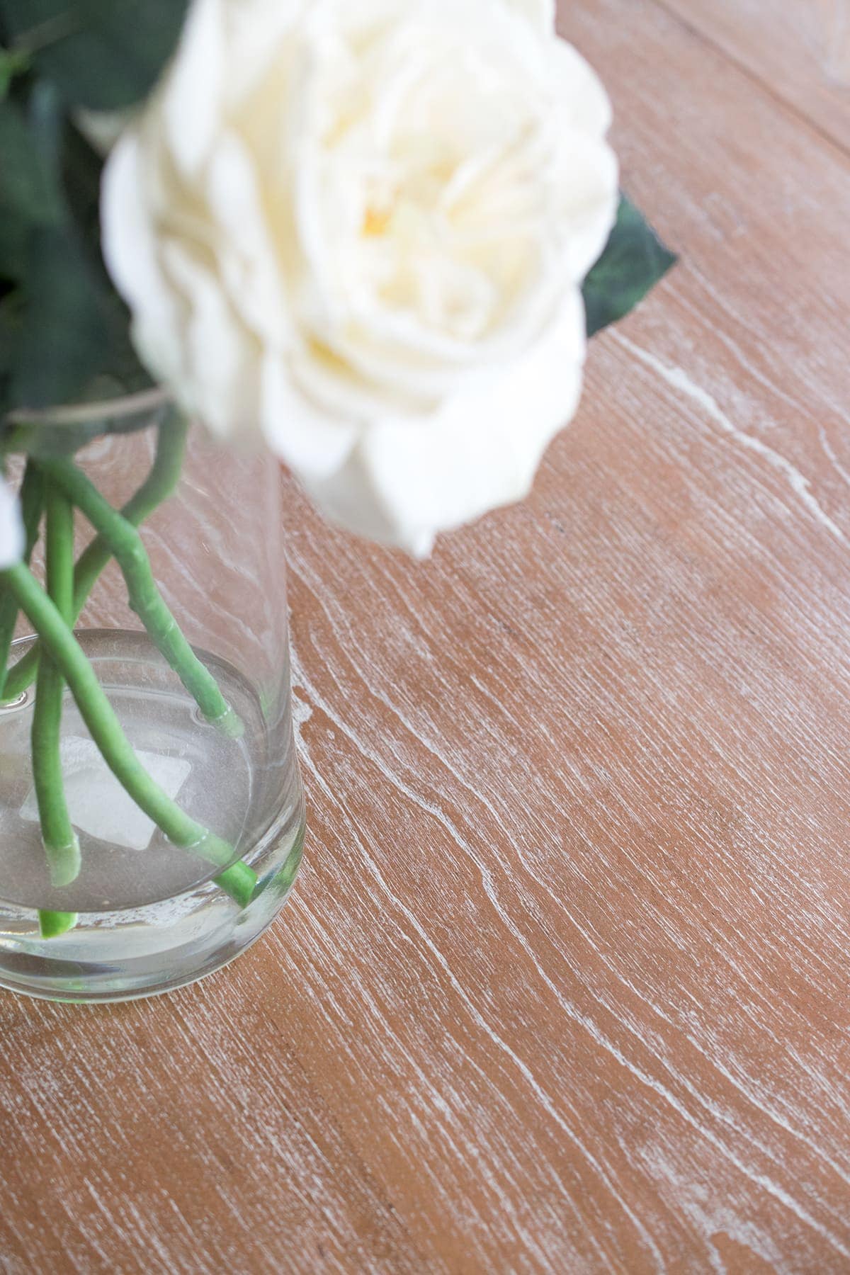 Close up of cerused finish wood grain on table top with white floral centerpiece