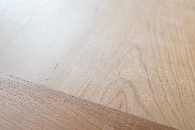 Closeup of stripped dining room table with wood grain.