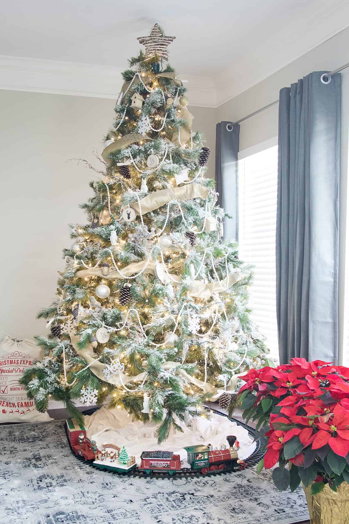 Woodland Christmas Tree with gold accents, natural pinecones, pearls, snowflakes. and a toy train around the tree.