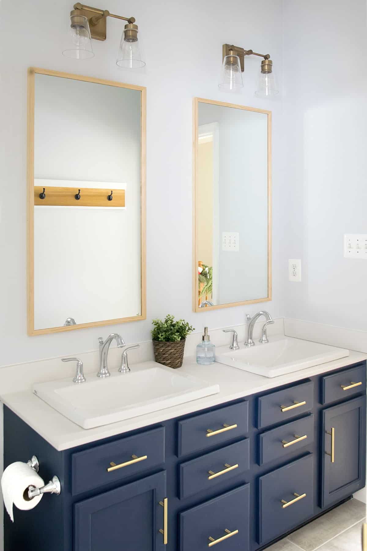 Navy Bathroom dual vanity with brass handles, drop in sinks and vintage faucets.