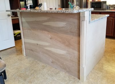 Kitchen island wrapped with plywood and corner posts.
