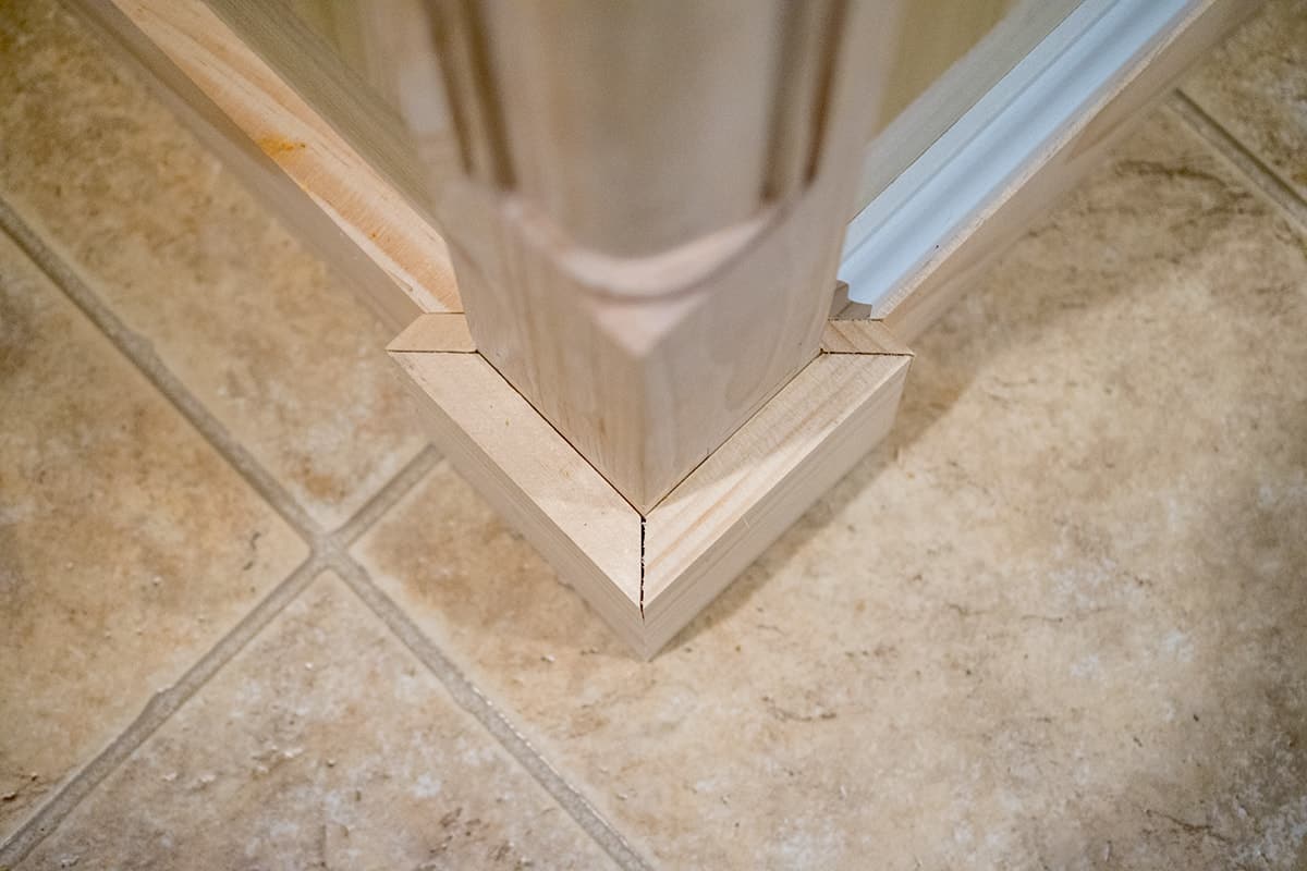 Corner posts on kitchen island showing how to cut baseboards.