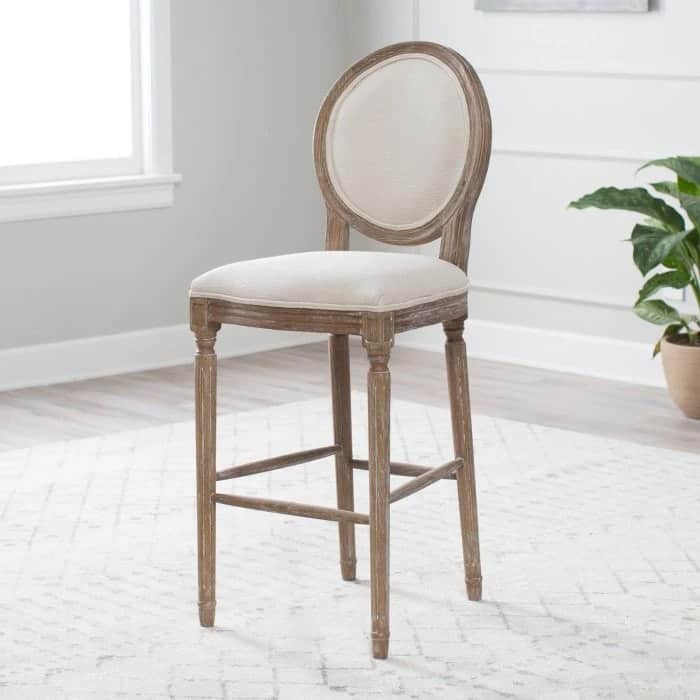Tall bar stool with round back sitting in a room.