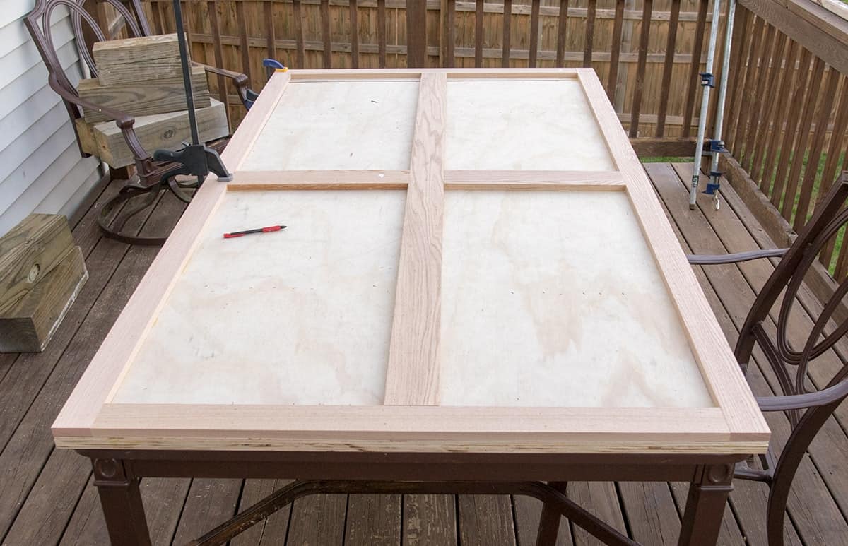 Wood patio table with support frame for herringbone pattern.